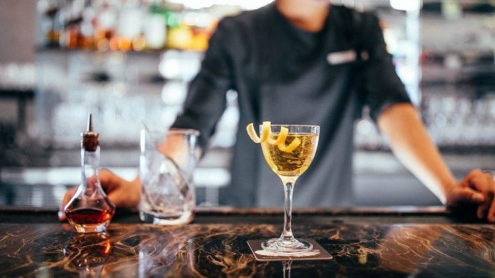 a man standing showing Unique Hotel Bars with Signature Cocktails